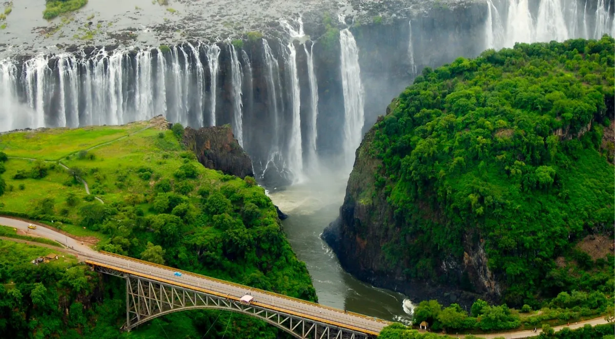 Aerial view of Victoria Falls and the historic Victoria Falls Bridge spanning the Batoka Gorge, with the Zambezi River winding below